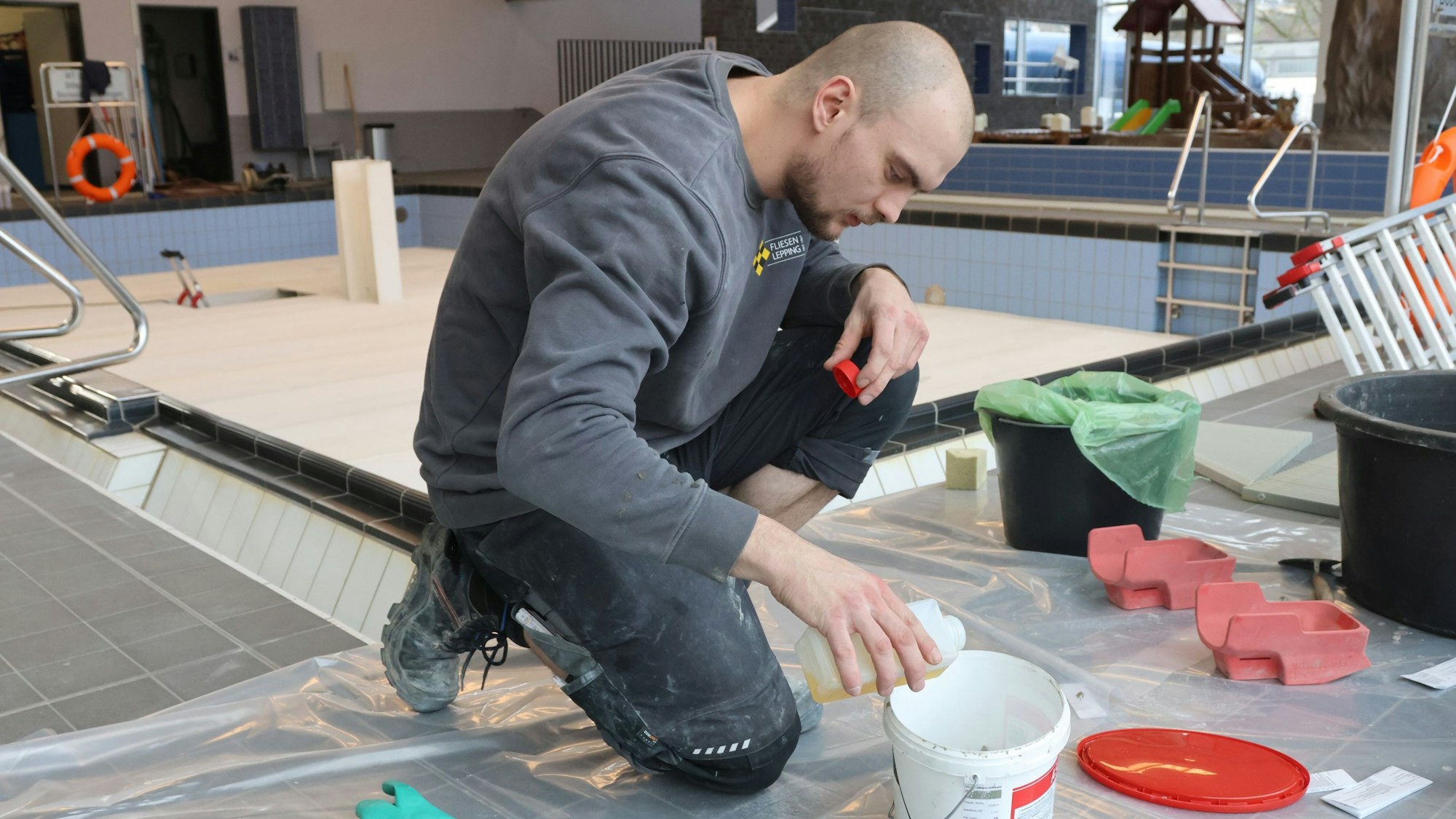Evgeny Krumm mischt Epoxidharzmörtel für die Fliesenfugen.