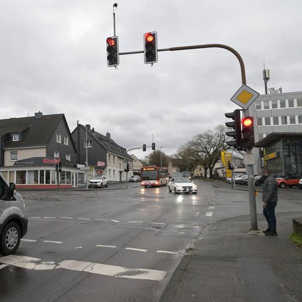 Eine Ampelkreuzung an der Paffrather Straße mit Autos, Bus und Fußgänger.