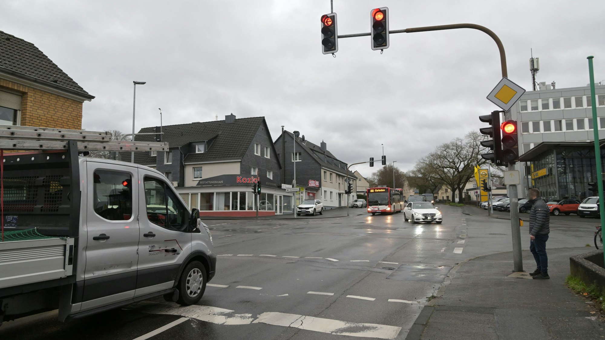 Eine Ampelkreuzung an der Paffrather Straße mit Autos, Bus und Fußgänger.