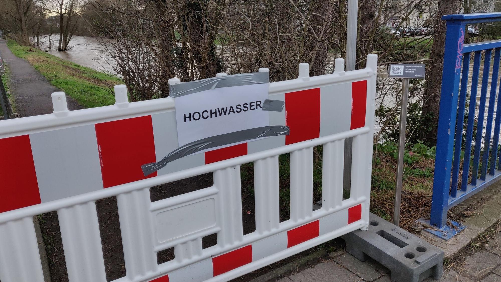 Ein Baugitter mit der Aufschrift "Hochwasser" steht am Wupperuferweg.