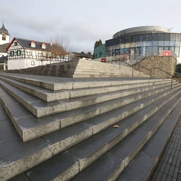 Eine Treppenanlage führt auf das runde Gebäude zu, das bis Ende Dezember das Sealife-Aquarium beherbergte. Im Hintergrund links ist der Turm der Pfarrkirche St-Remigius zu sehen..