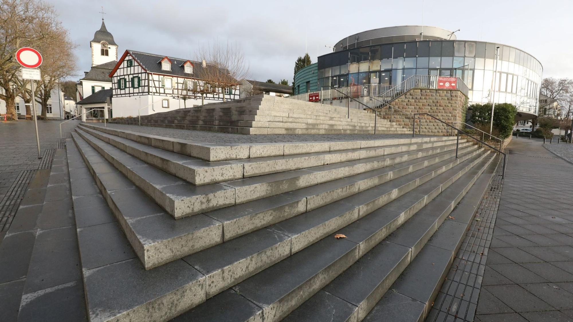 Graue Treppenstufen führen zu dem Rundbau, der bis zum 31. Dezember das Sea Life beherbergte. Links im Hintergrund ist der Turm der Pfarrkirche St. Remigius zu sehen.