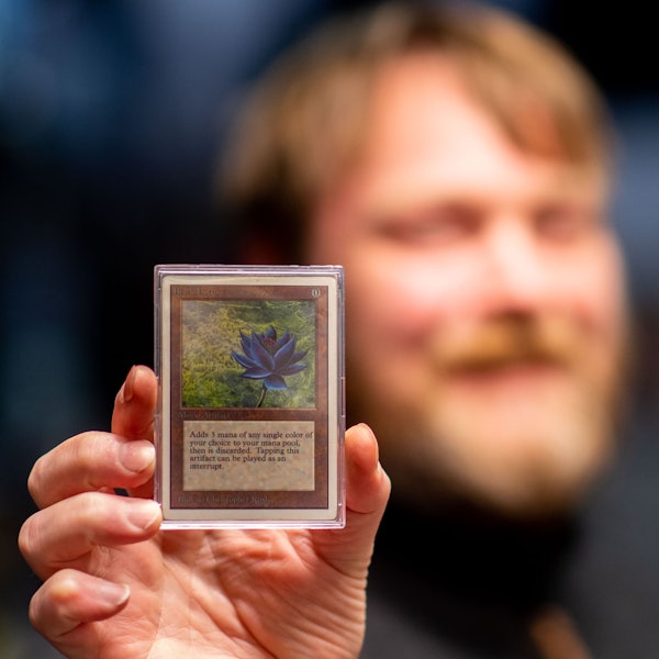 Der Besitzer des Fantasy Store in Euskirchen hält eine seltene Spielkarte in der Hand.