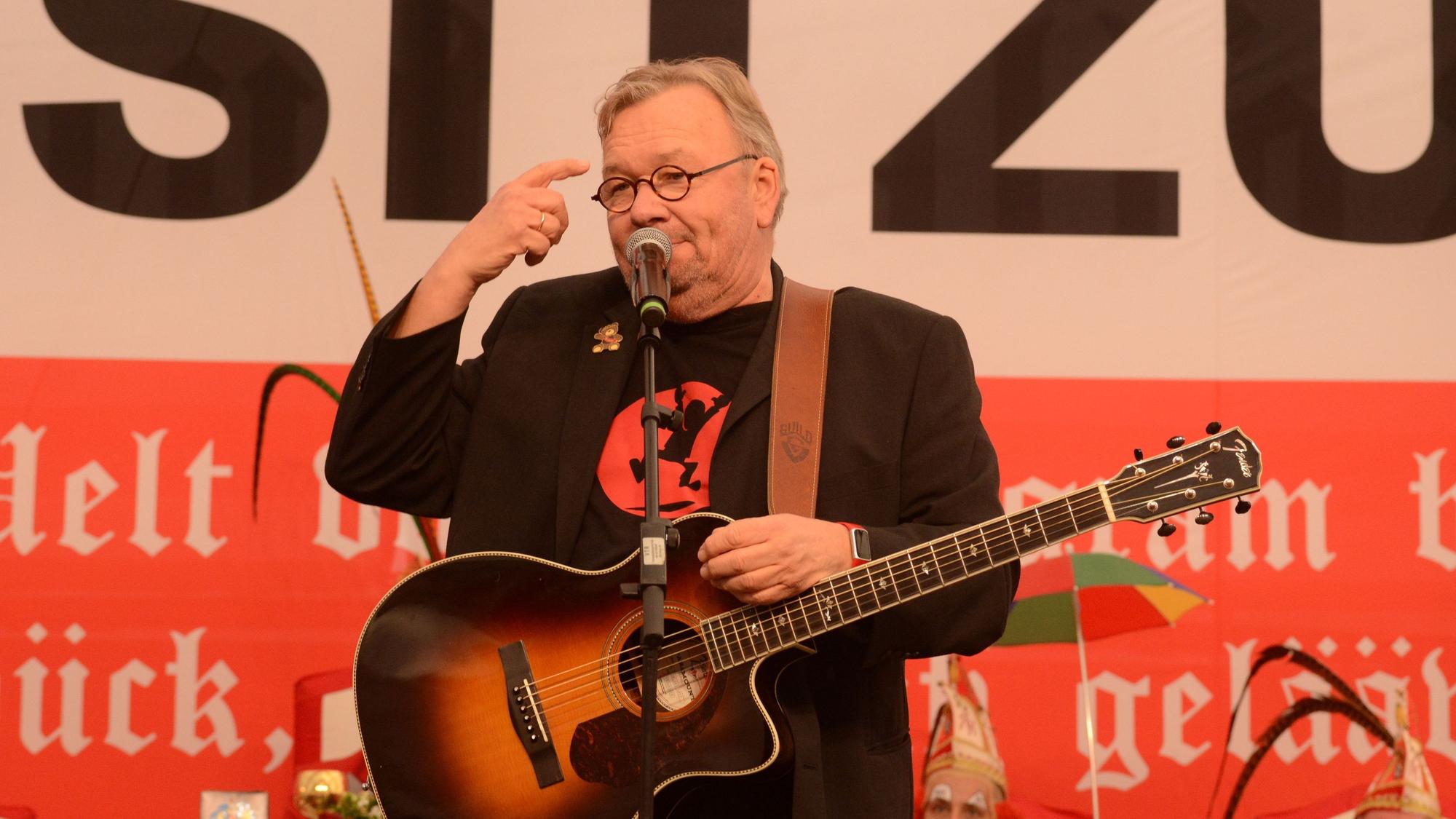 Stelter mit Gitarre, zeigt den Vogel.