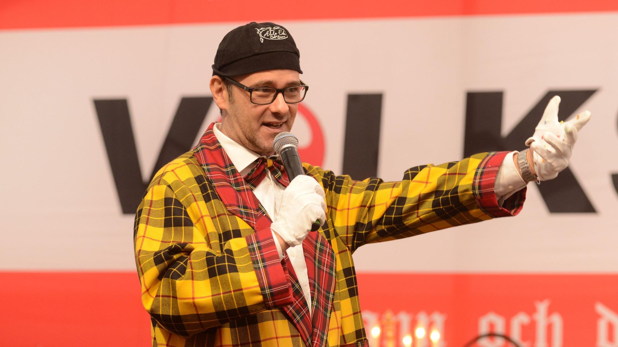 Metzger verkleidet auf der Bühne mit Mikro.