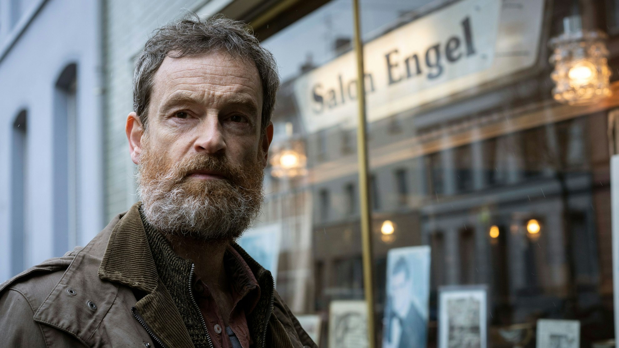 Peter Faber (Jörg Hartmann) steht mit zerzaustem Bart und Haar vor dem Frisörsalon Engel. Sein Blick geht ausdruckslos ins Leere.