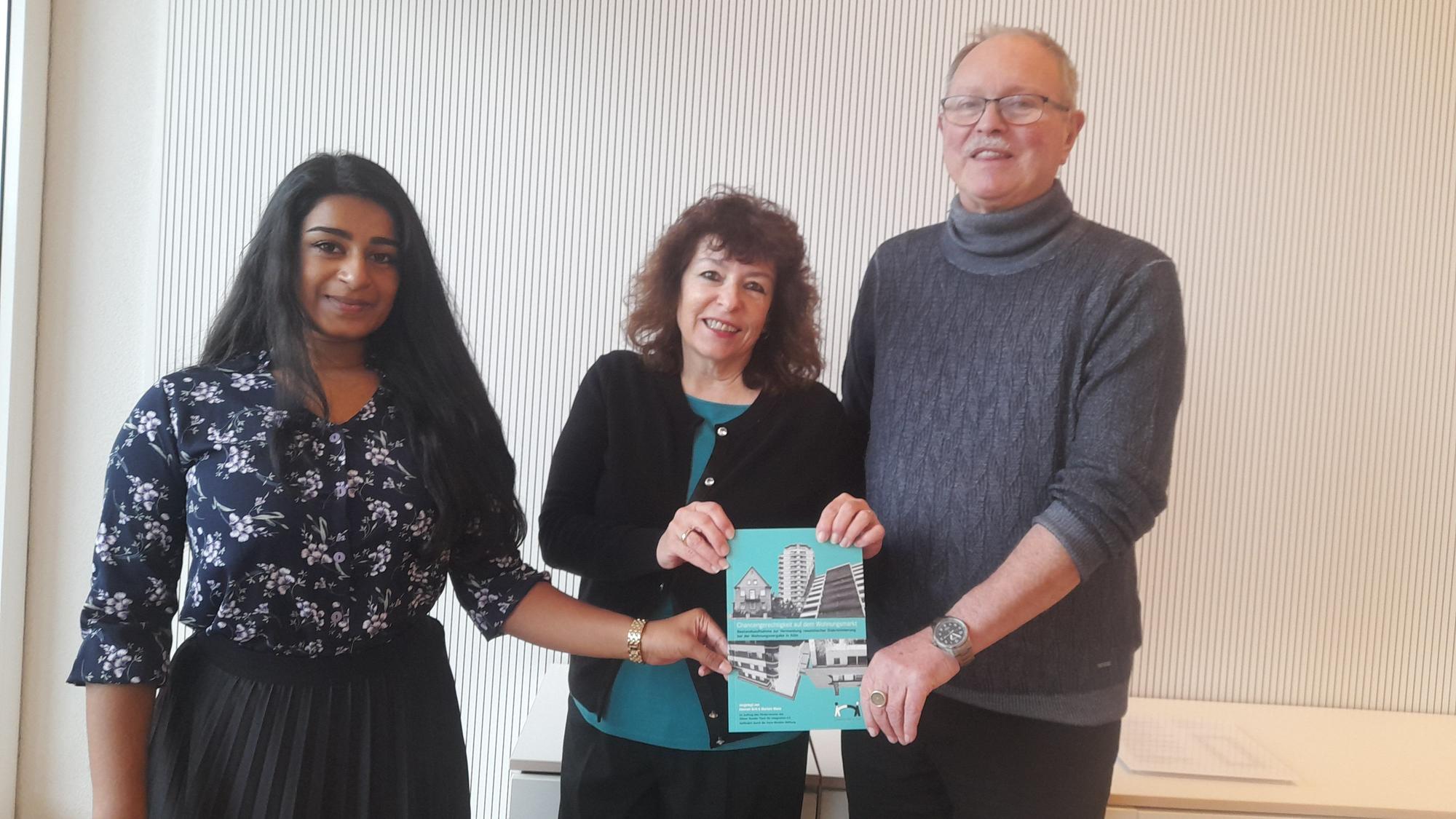 Thivitha Himmen, Maristella Angioni und Wolfgang Uellenberg-van Dawen (v.l.) vom Runden Tisch für Integration zeigen den Bericht für Chancengerechtigkeit am Kölner Wohnungsmarkt.