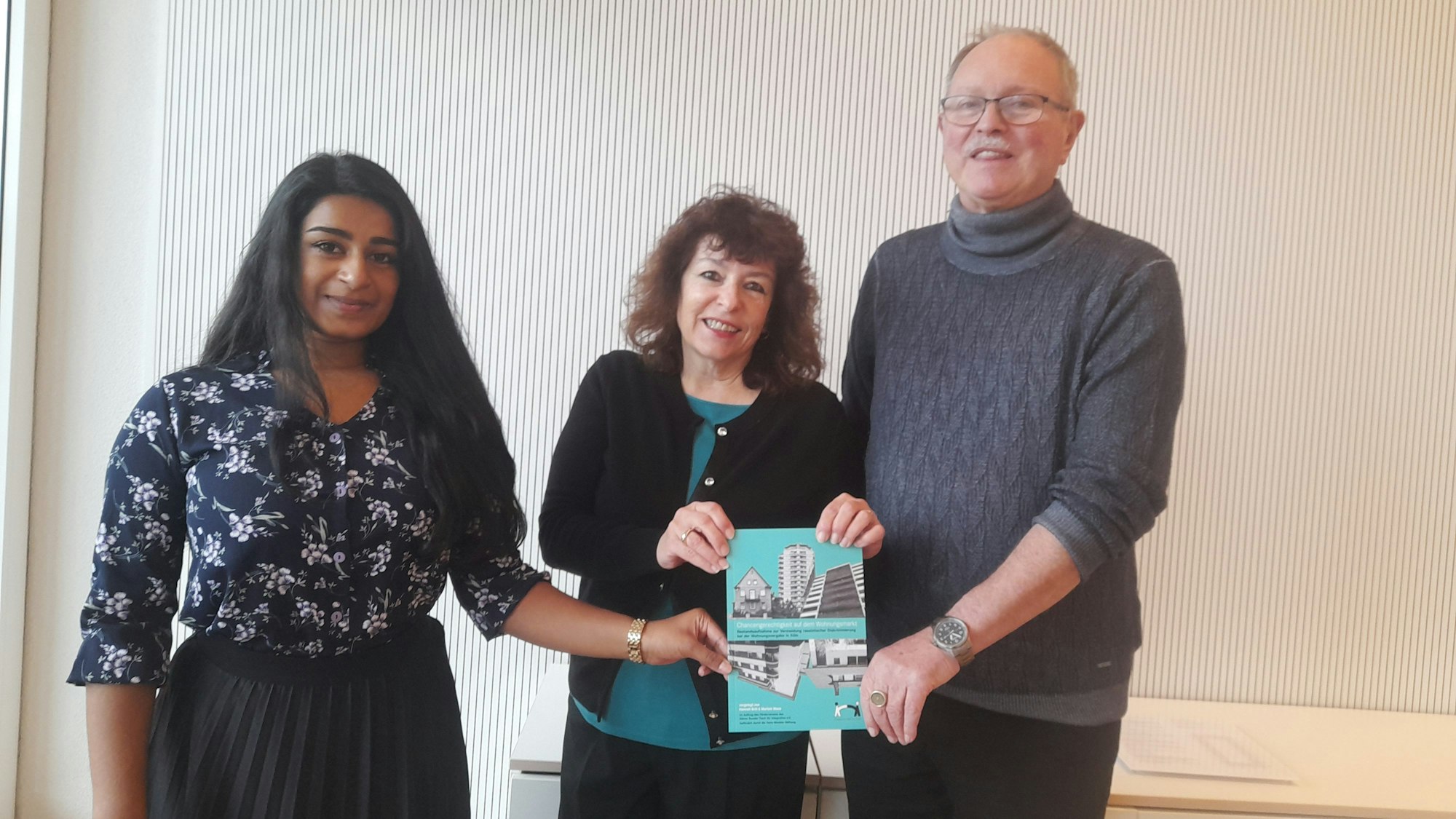 Thivitha Himmen, Maristella Angioni und Wolfgang Uellenberg-van Dawen (v.l.) vom Runden Tisch für Integration zeigen den Bericht für Chancengerechtigkeit am Kölner Wohnungsmarkt.