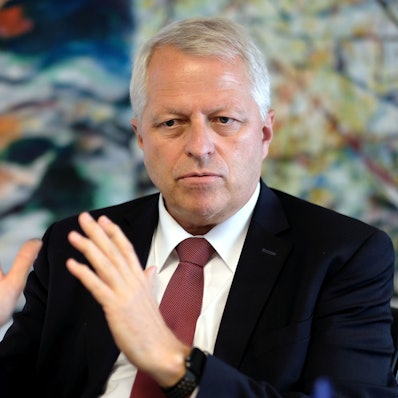 Jürgen Mathies sitzt hinter einem Schreibtisch und gestikuliert im Gespräch mit seinen Händen