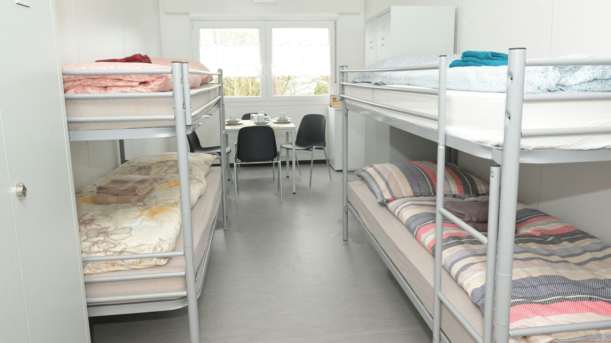 Ein Blick in die Container: Vier Betten, dazu ein Schrank und ein Tisch mit vier Stühlen.