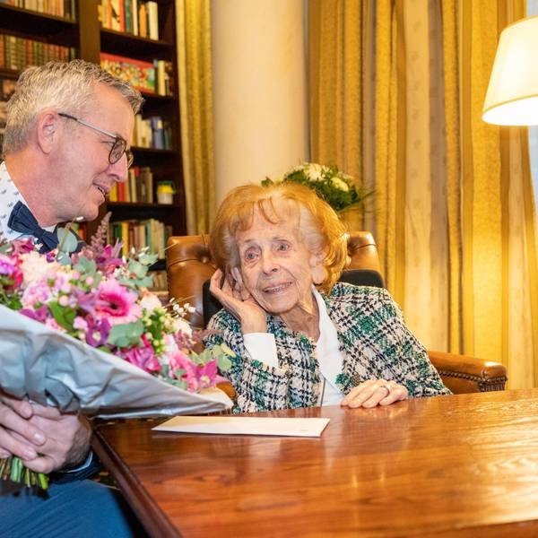 Wolter überreicht Steubesand am Tisch einen Blumenstrauß.