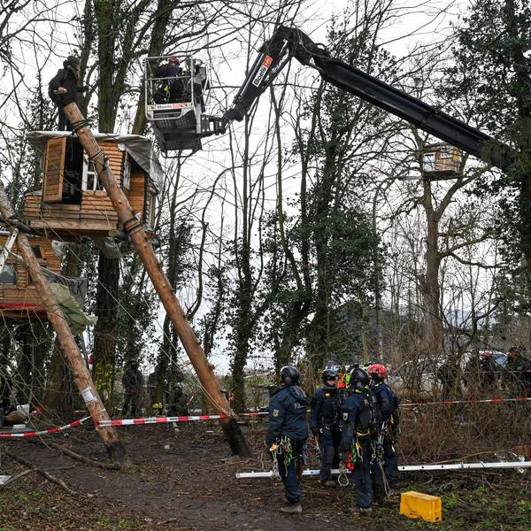 Polizisten sprechen von einer Hebebühne aus mit einem Aktivisten der am dritten Tag der Räumung im von Klimaaktivisten besetzten Braunkohleort Lützerath auf einem Baumhaus steht. Der Energiekonzern RWE will die unter Lützerath liegende Kohle abbaggern - dafür soll der Weiler auf dem Gebiet der Stadt Erkelenz am Braunkohletagebau Garzweiler II abgerissen werden.