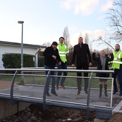 Harald Nauroschat (v.l.) vom Forscherteam, Geschäftsführer Volker Salentin, Bürgermeister Ralph Manzke, Geschäftsführende Gesellschafterin Jutta Graf und Bauleiter Tim Hammitzsch stehen auf einer neuen Brücke.