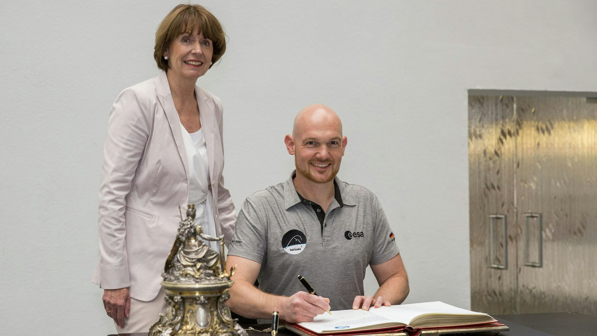 Alexander Gerst ist zu Gast im Kölner Rathaus bei der Oberbürgermeisterin Henriette Reker und trägt sich ins goldene Buch der Stadt Köln ein.