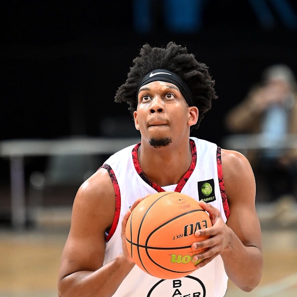 Ein Basketballer richtet vor einem Freiwurf den Blick auf den Korb.