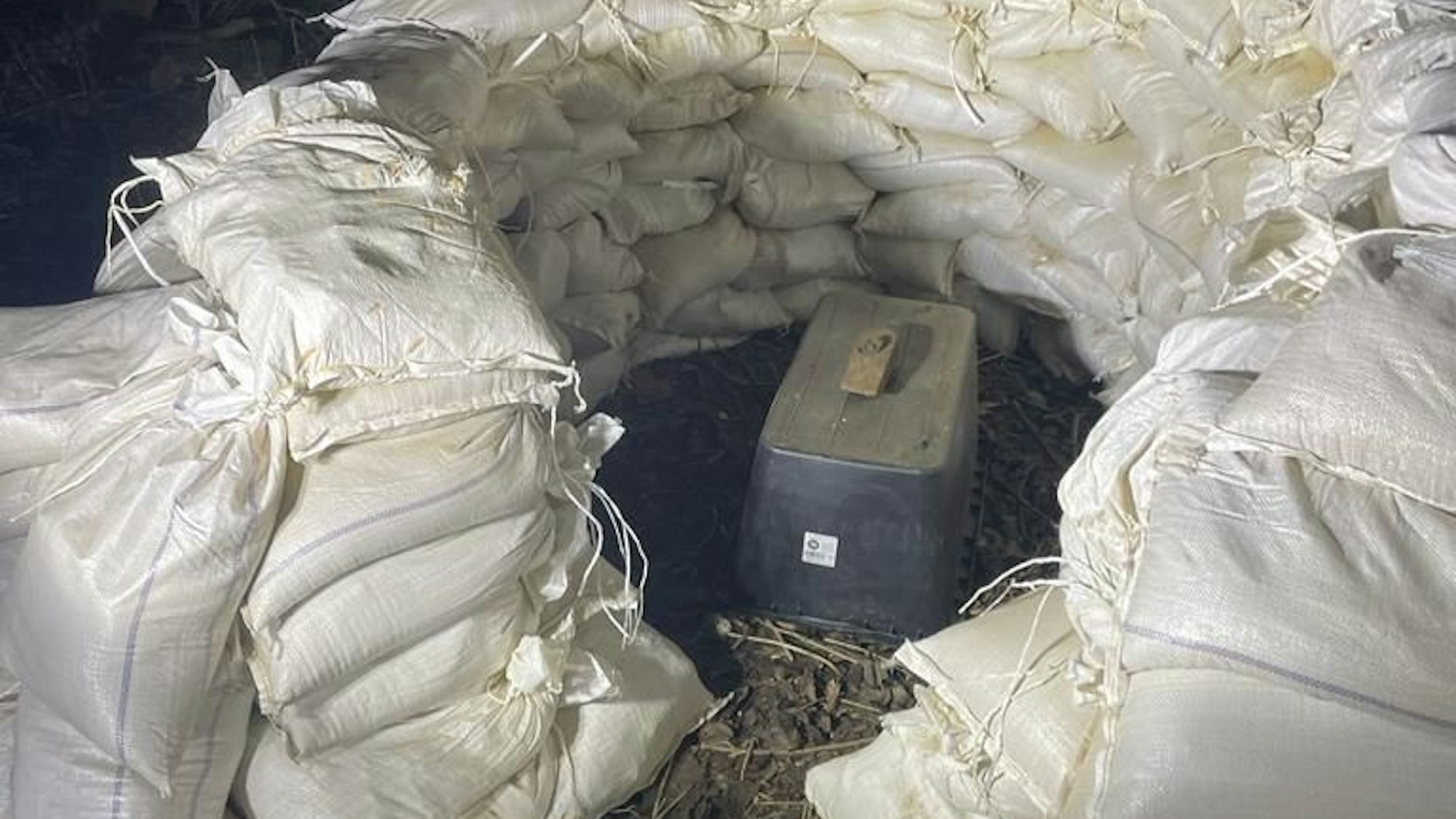 Eine Tellermine aus dem Zweiten Weltkrieg ist von Sandsäcken umringt.