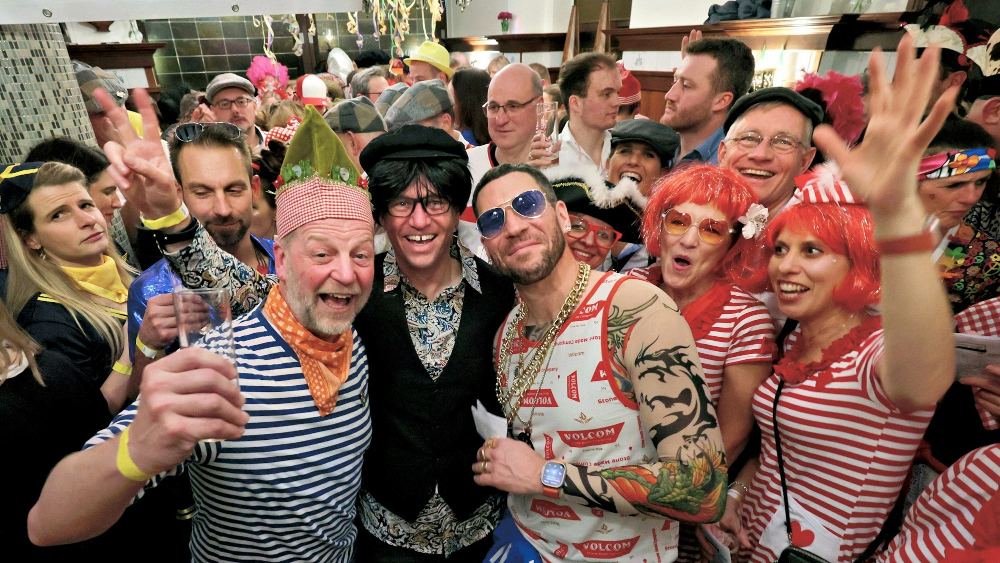 Im vollen Schankraum herrscht gute Stimmung, verkleidete Männer und Frauen lachen in die Kamera.