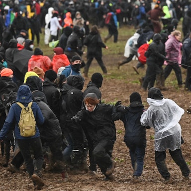 Berittene Polizisten drängen Demonstrierende von der Tagebaukante weg.