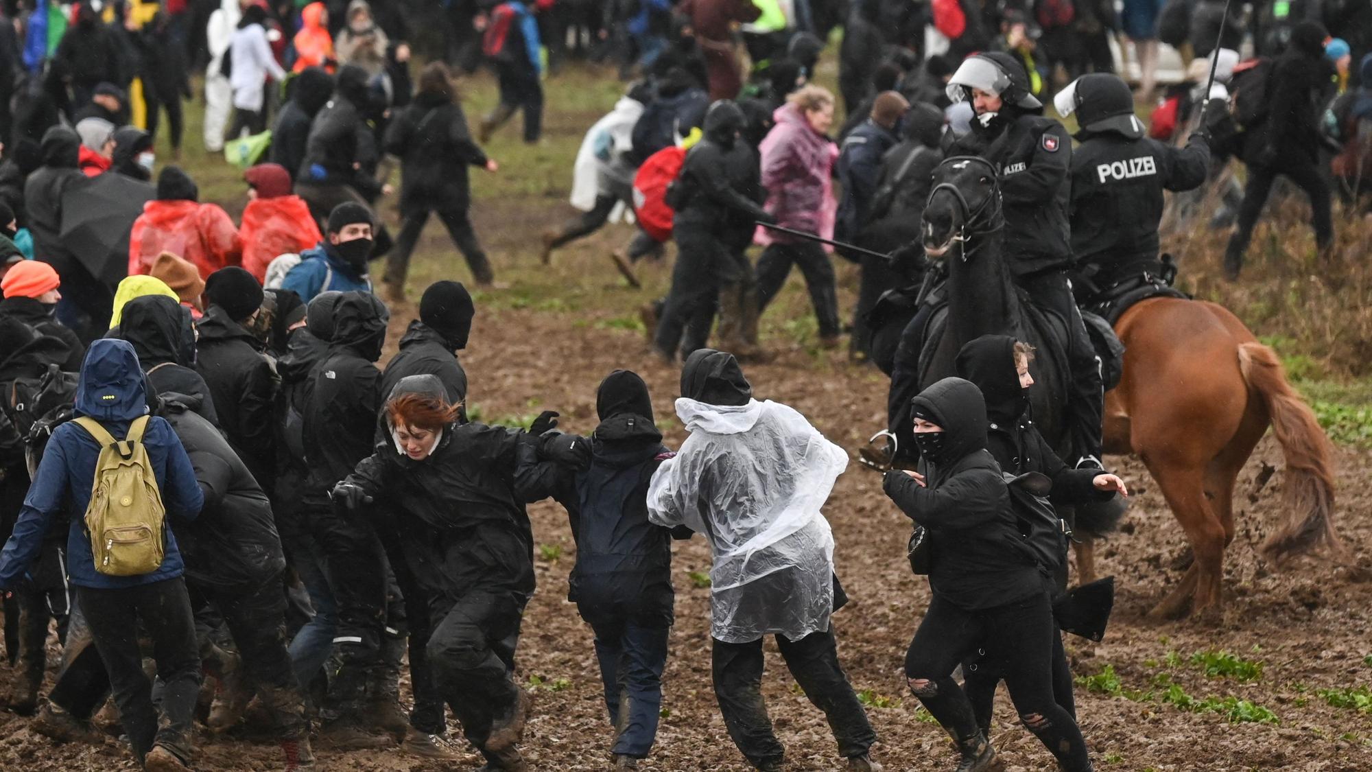 Bei der Großdemonstration im Braunkohledorf Lützerath treffen Demonstranten und Polizisten auf Pferden aufeinander.