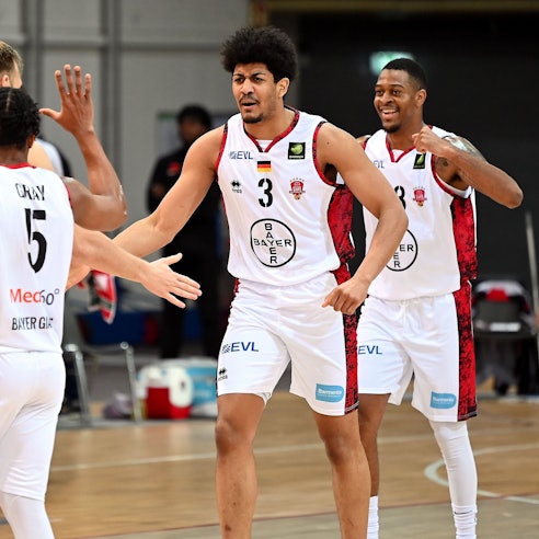 Vier Basketballspieler jubeln und klatschen sich ab.