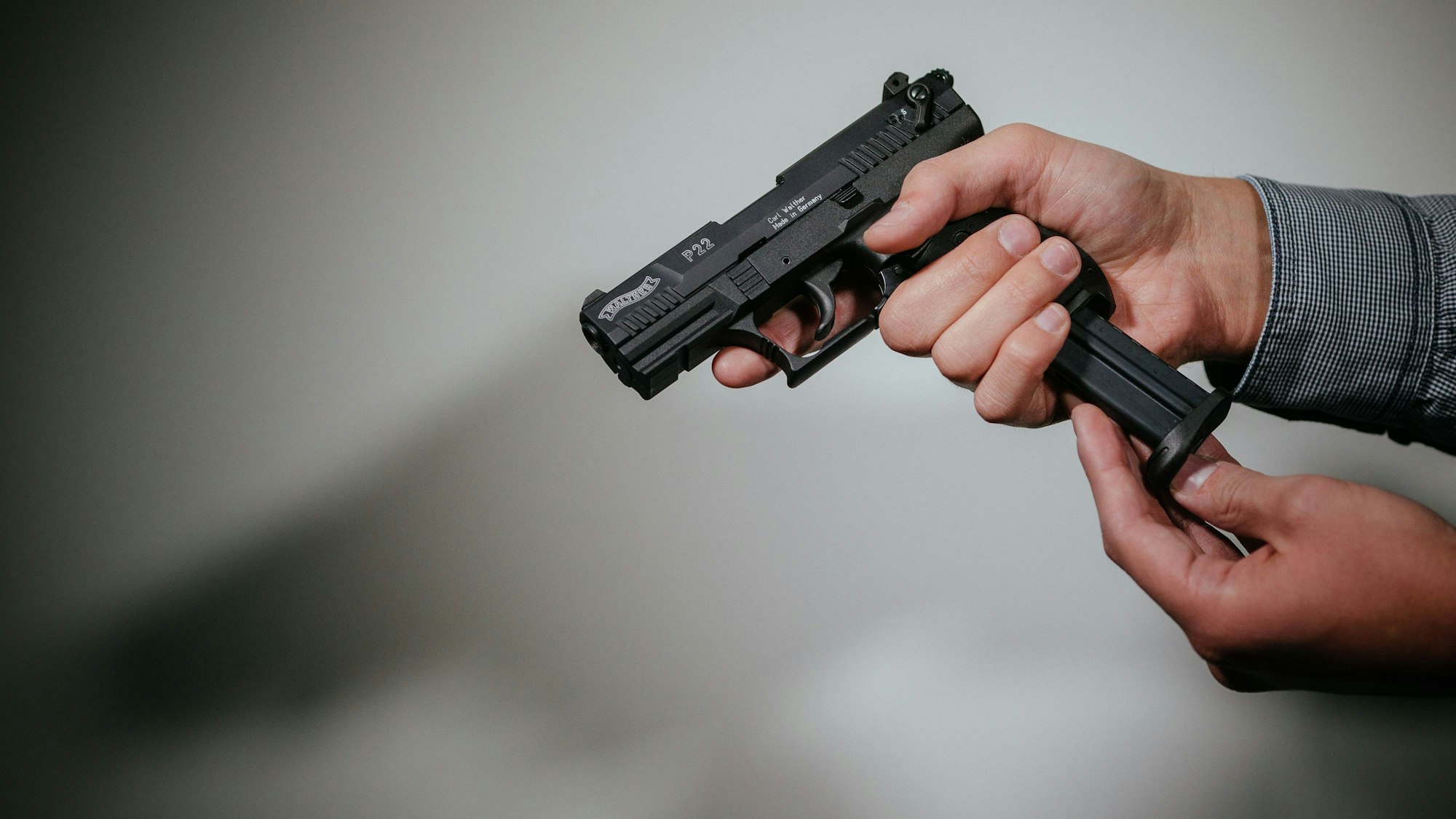 Ein Mann lädt eine Schreckschuss-Pistole.