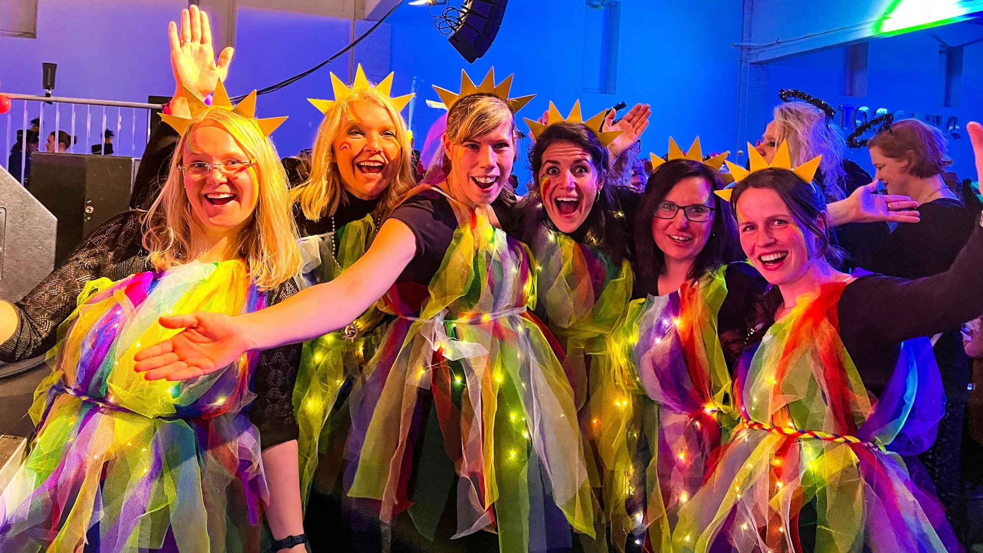 Sechs Frauen posieren für die Kamera, sie sind als Sternenmädchen verkleidet, mit Sternen auf dem Kopf und leuchtenden Gewändern.