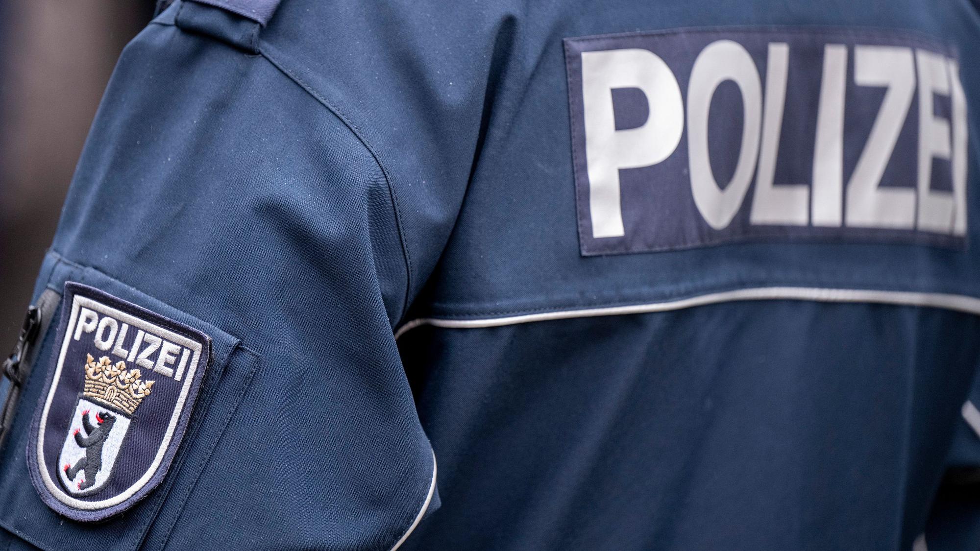 Die Aufschrift Polizei und der Wappen von Berlin auf der Uniform eines Polizeibeamten