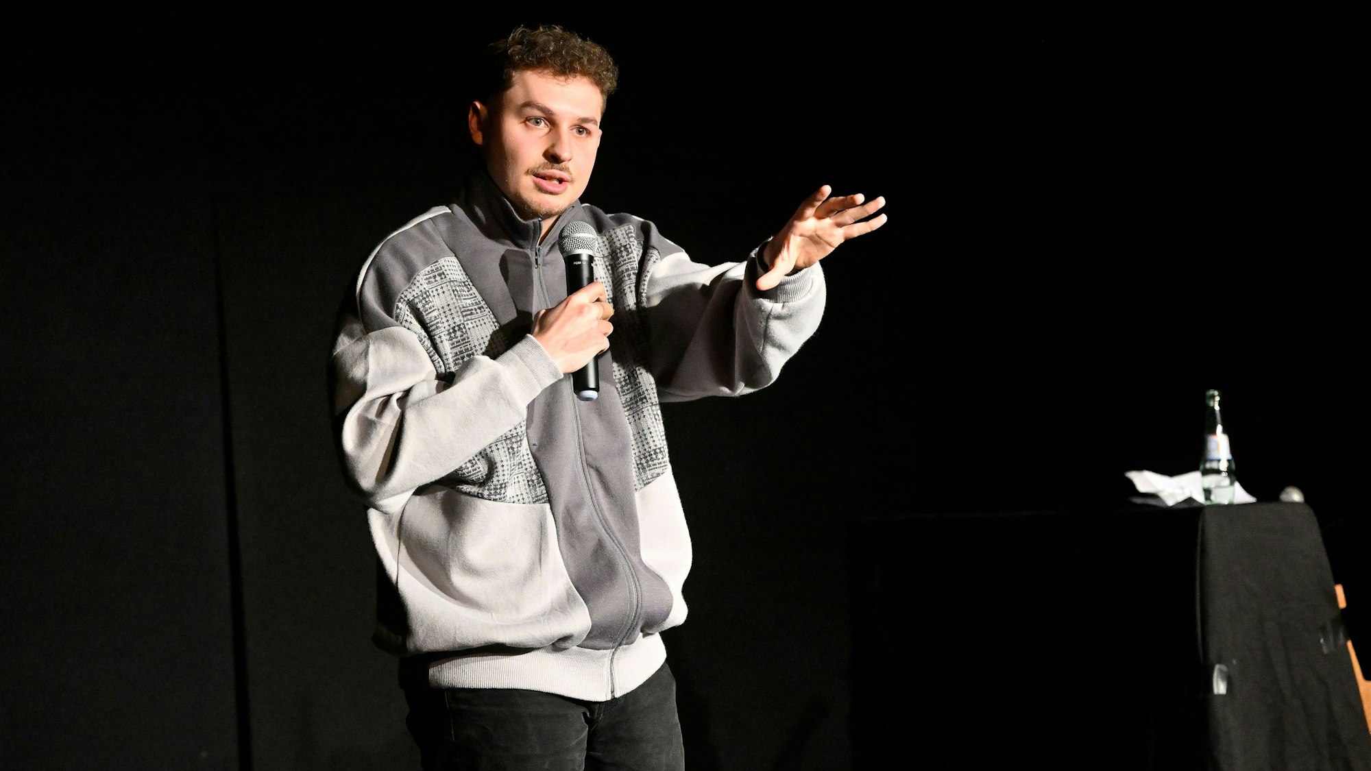 Fabian Lampert steht auf der Bühne vor dunklem Vorhang und referiert im Theas-Theater über Alkoholprobleme.