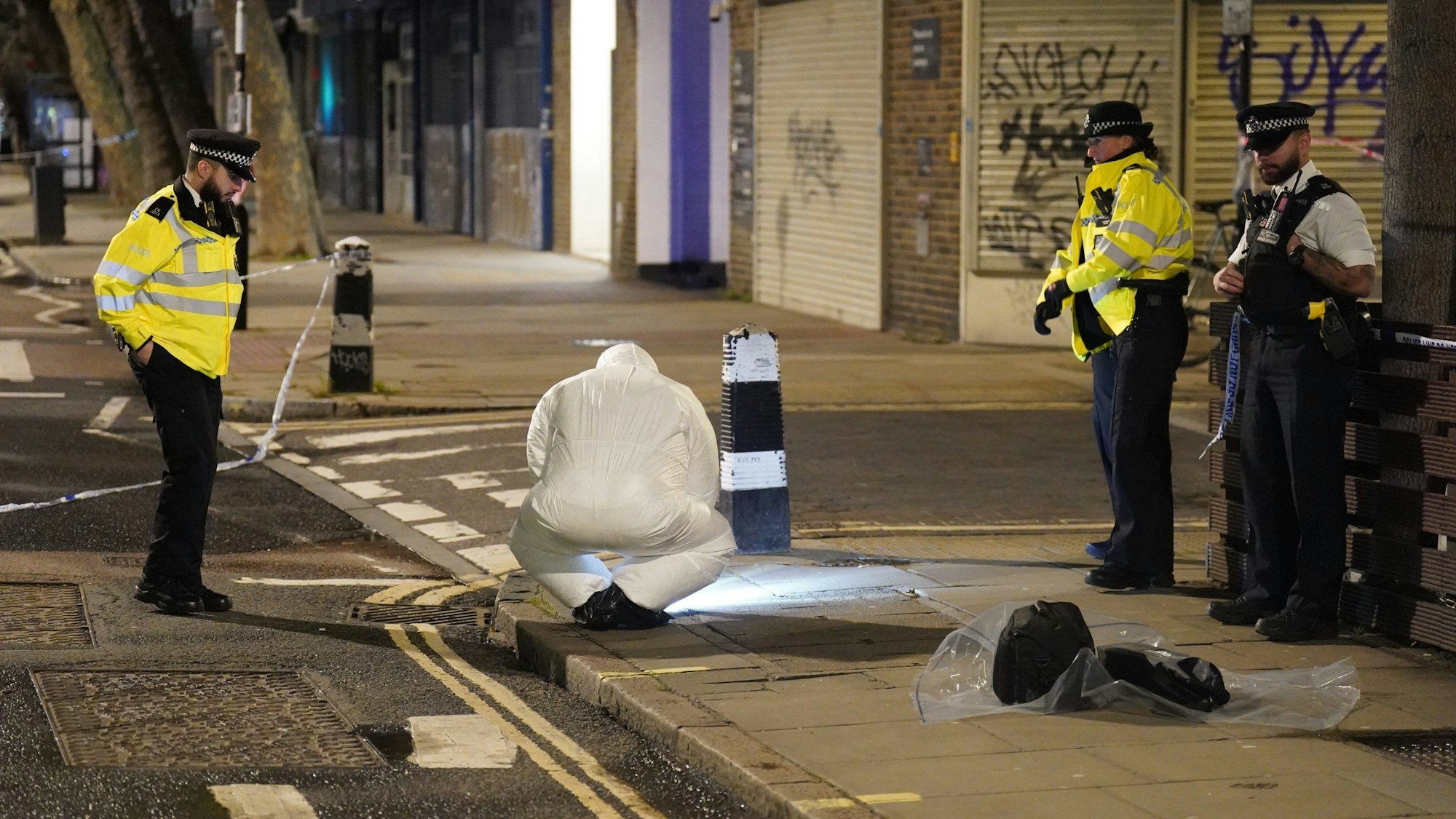 14.01.2023, Großbritannien, London: Ein Beamter der Spurensicherung arbeitet in der Nähe des Tatorts.