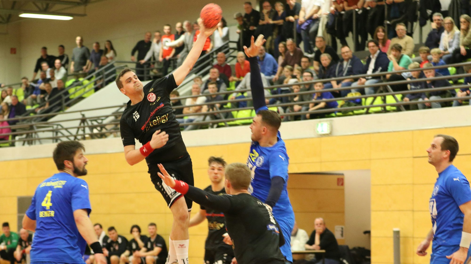 NIls Schouren vom TV Palmersheim steigt höher als alle anderen Spieler. Im Hintergrund sind die Zuschauer zu erkennen.