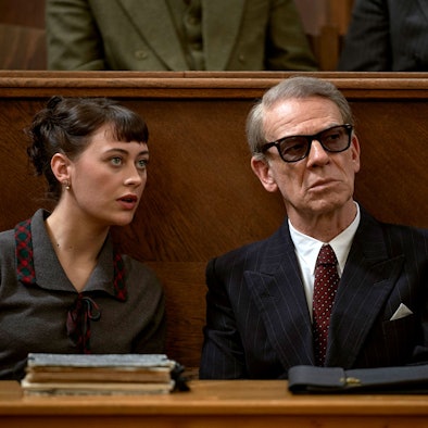 Toni (Mercedes Müller, l.) übersetzt für Gehlen (Martin Wuttke, r.) bei einer Verhandlung. Sie trägt ein graues Kostüm, er einen schwarzen Anzug und eine Sonnenbrille.