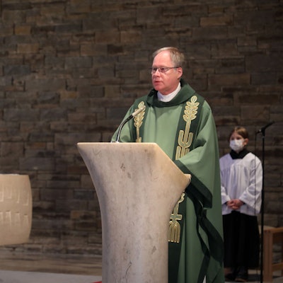 Pfarrer Wilhelm Darscheid steht am Ambo der katholischen Kirche in Bergisch Gladbach-Hand.