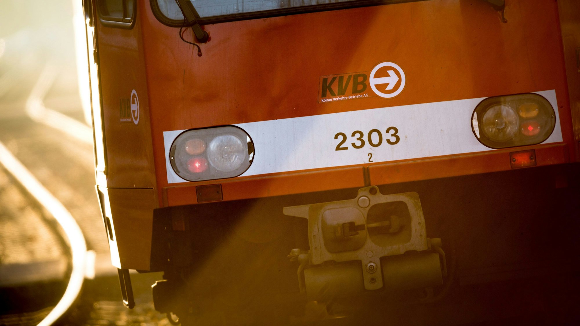 Eine Straßenbahn der KVB fährt im Morgenlicht über das Gleis.