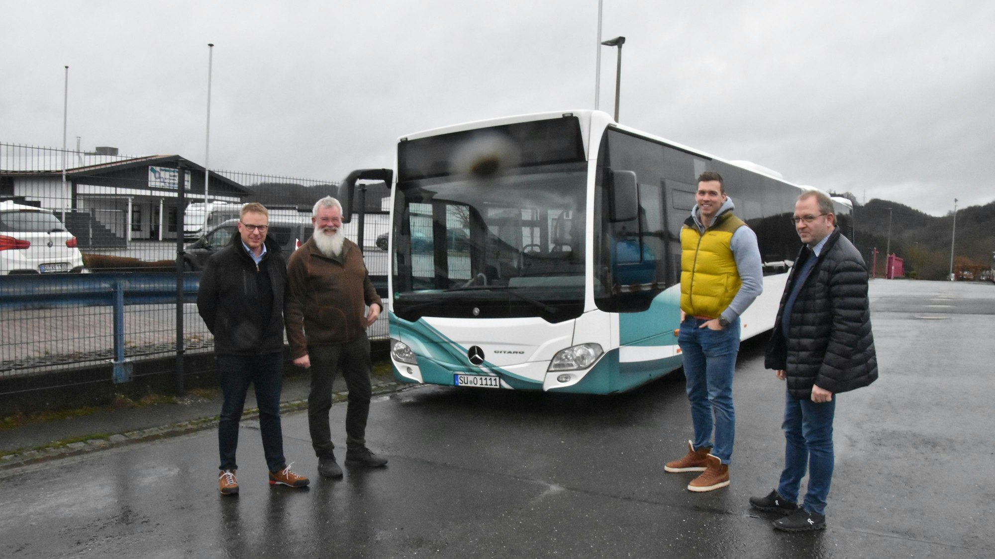 Vier Busunternehmer aus dem Rhein-Sieg-Kreis stehen vor einem Bus.
