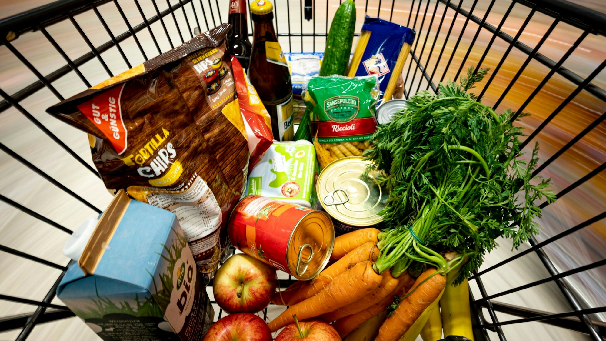 Ein Einkauf liegt in einem Einkaufswagen in einem Supermarkt.