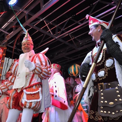 Das Dreigestirn tanzt gutgelaunt auf einer Bühne.