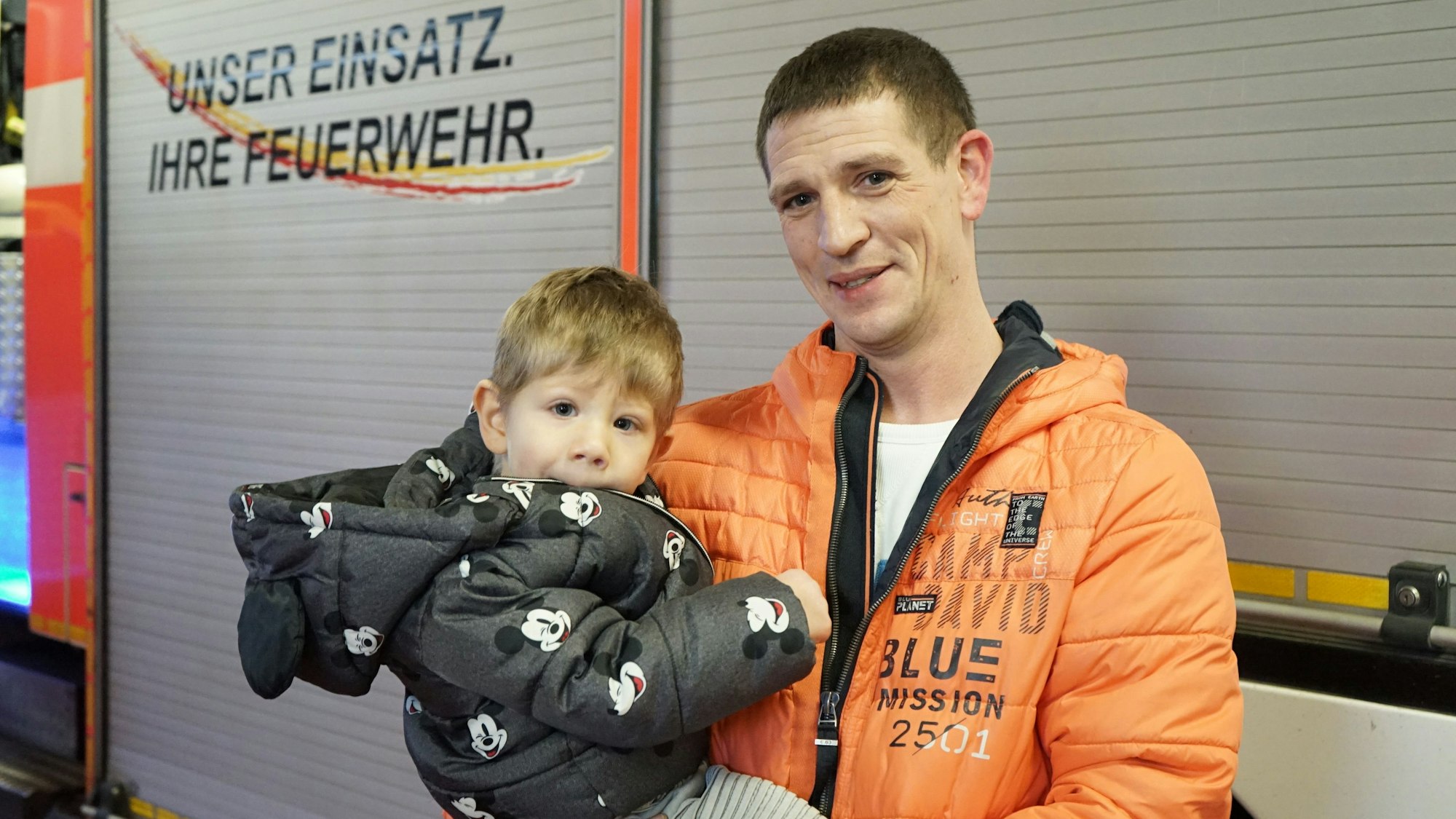 Der dreijährige Linus mit seinem Vater Michael vor einem Feuerwehrwagen.