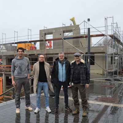 Vier Männer stehen vor der Baustelle eines neuen Hauses am Kaller Bahnhof.