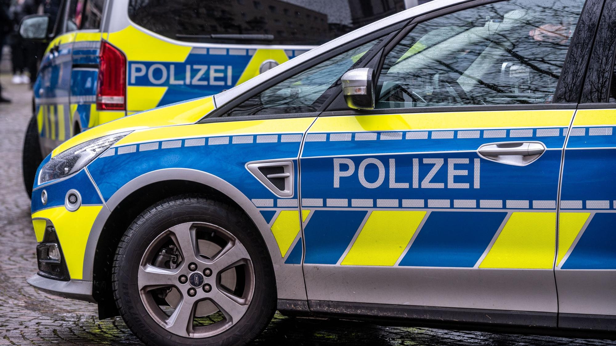 Zwei Polizeifahrezuge sind zu sehen.