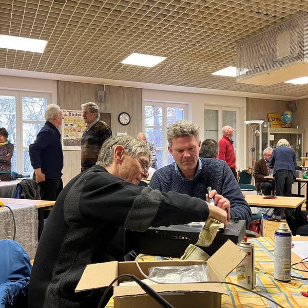 Zwei Männer reparieren einen alten Verstärker.