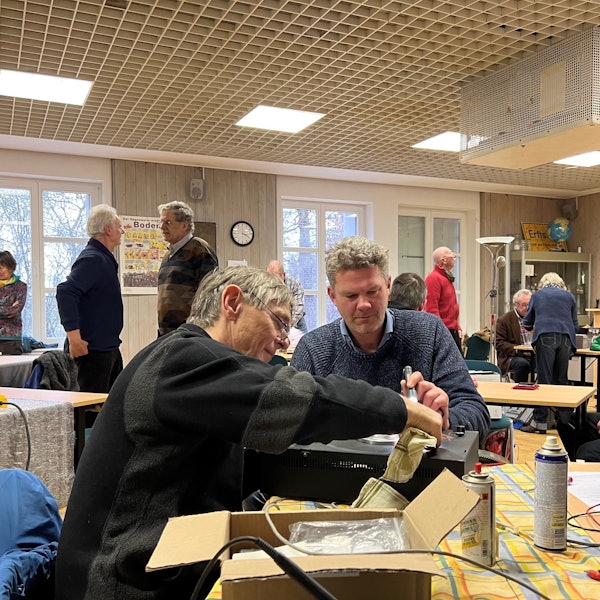 Zwei Männer reparieren einen alten Verstärker.