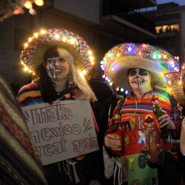 Drei als Geister geschminkte Menschen mit Sombreros mit Lichterketten.