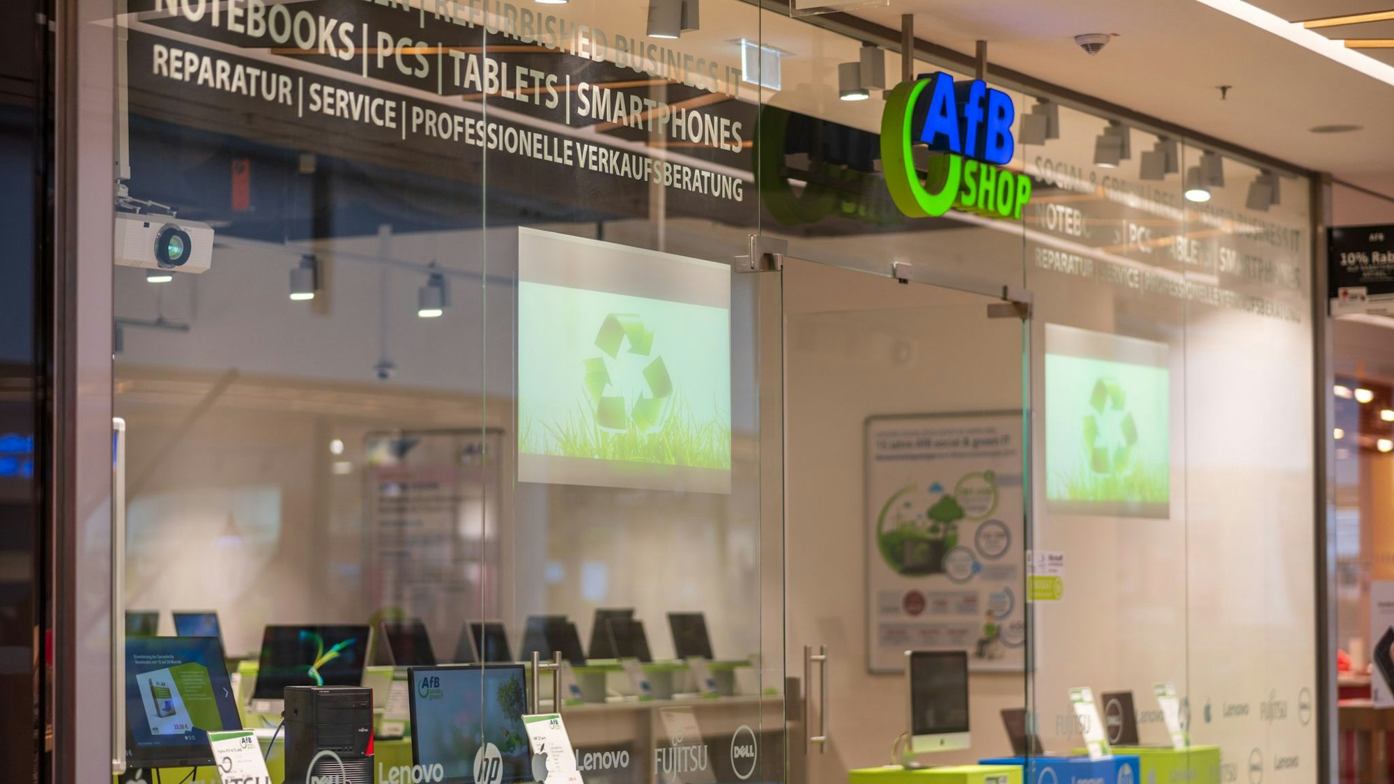Außenansicht des AfB-Shops in den Köln Arcarden in Köln-Kalk. IM Schaufenster sind diverse PCs und Notebooks zusehen.