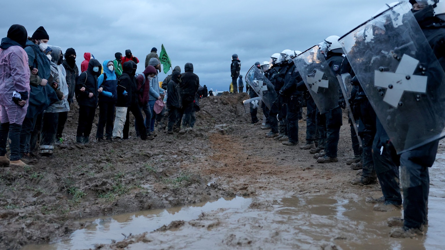 Polizisten und Demonstranten stehen sich bei der Demonstration von Klimaaktivisten am Rande des Braunkohletagebaus bei Lützerath gegenüber.