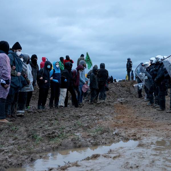 Polizisten und Demonstranten stehen sich bei der Demonstration von Klimaaktivisten am Rande des Braunkohletagebaus bei Lützerath gegenüber.