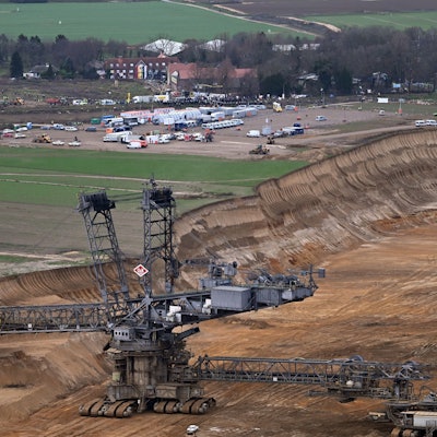 Polizeiautos und Polizisten stehen vor der Ortschaft Lützerath.