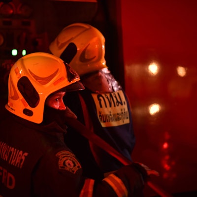 Thailändische Feuerwehrleute sind im Einsatz bei einem Brand.