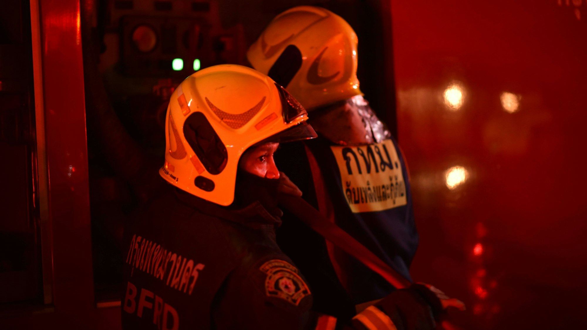 Thailändische Feuerwehrleute sind im Einsatz bei einem Brand.