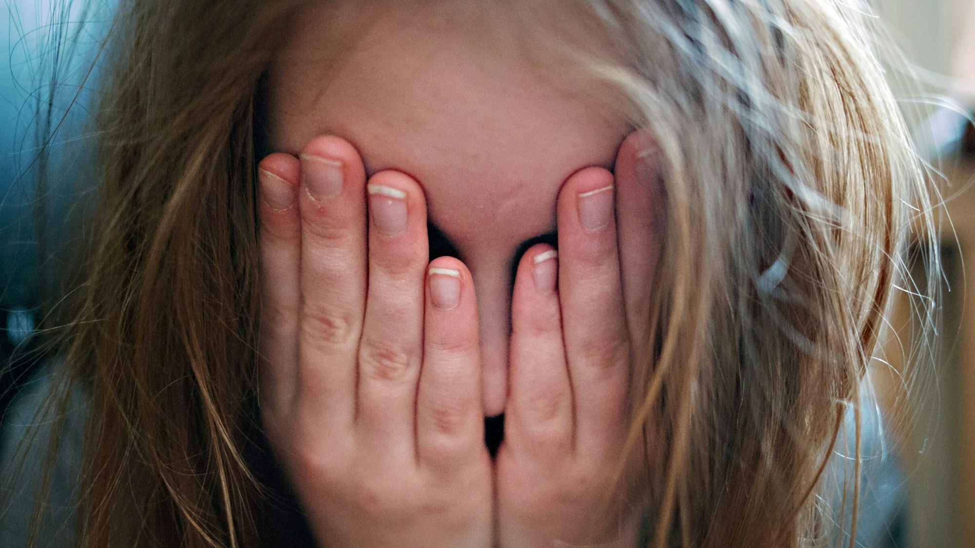 24.01.2014, Berlin: Ein junges Mädchen hält sich die Hände vor ihr Gesicht.