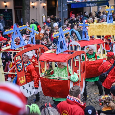 Teilnehmer des Rosenmontagszugs in Köln sind als Seilbahn-Gondeln verkleidet.
